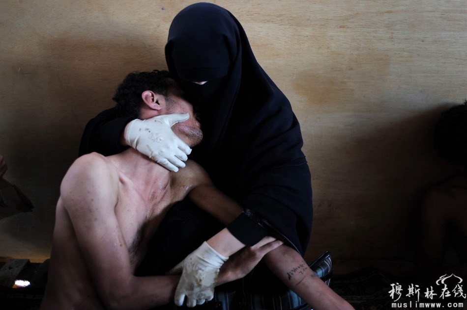 2011年10月15日，也门首都萨那，一位妇女抱着在反对总统萨利赫统治的示威中受伤的亲属。摄影师：Samuel Aranda 国籍：西班牙 所在单位：Corbis图片社