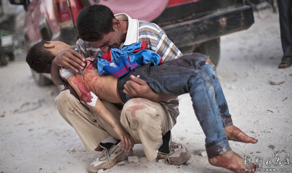 图为当地时间10月3日，叙利亚阿勒颇Dar El Shifa医院附近，一名男子抱着儿子的遗体哭泣。当天发生在阿勒颇市的连环爆炸造成34人死亡122人受伤。 Manu Brabo/摄