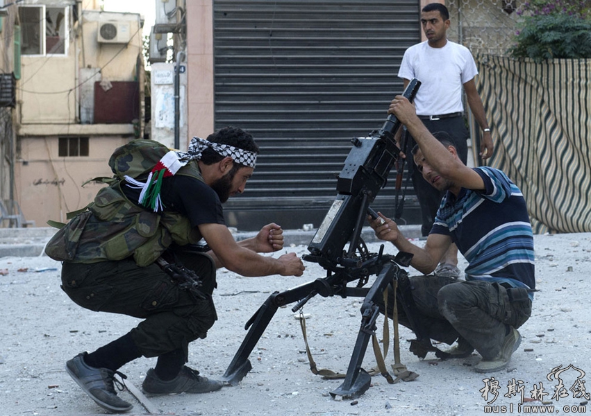 当地时间9月27日，阿勒颇，两名叙利亚自由军战士修理一架枪榴弹发射器。 Miguel Medina/摄