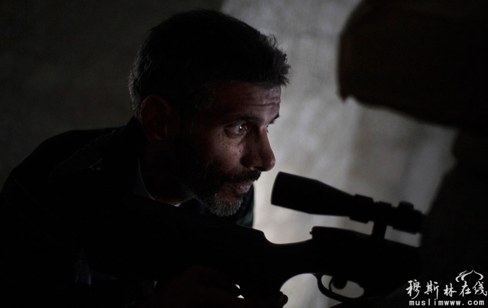 当地时间9月23日，阿勒颇Izaa街区，一名隐蔽在建筑物内的反对派狙击手瞄准目标。 Manu Brabo/摄