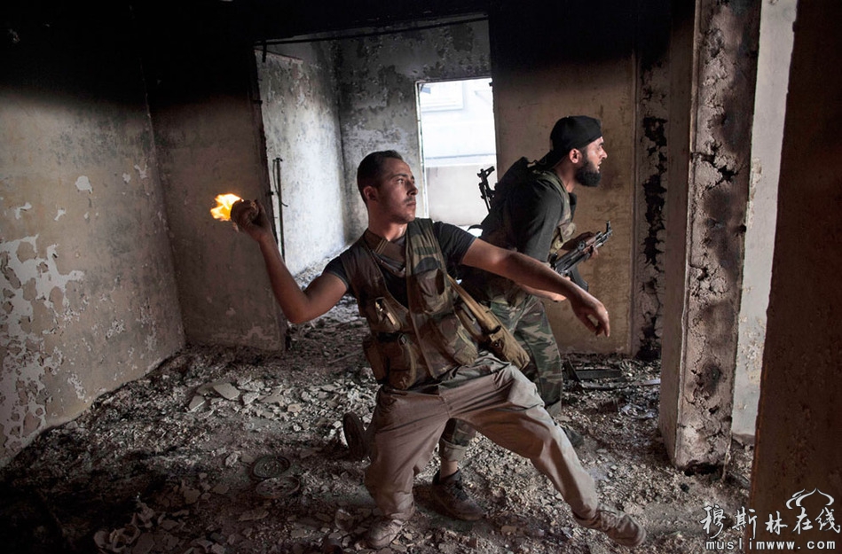 当地时间10月3日，阿勒颇Saif Al Dawle街区，叙利亚自由军战士向政府军投掷汽油弹。 Manu Brabo/摄