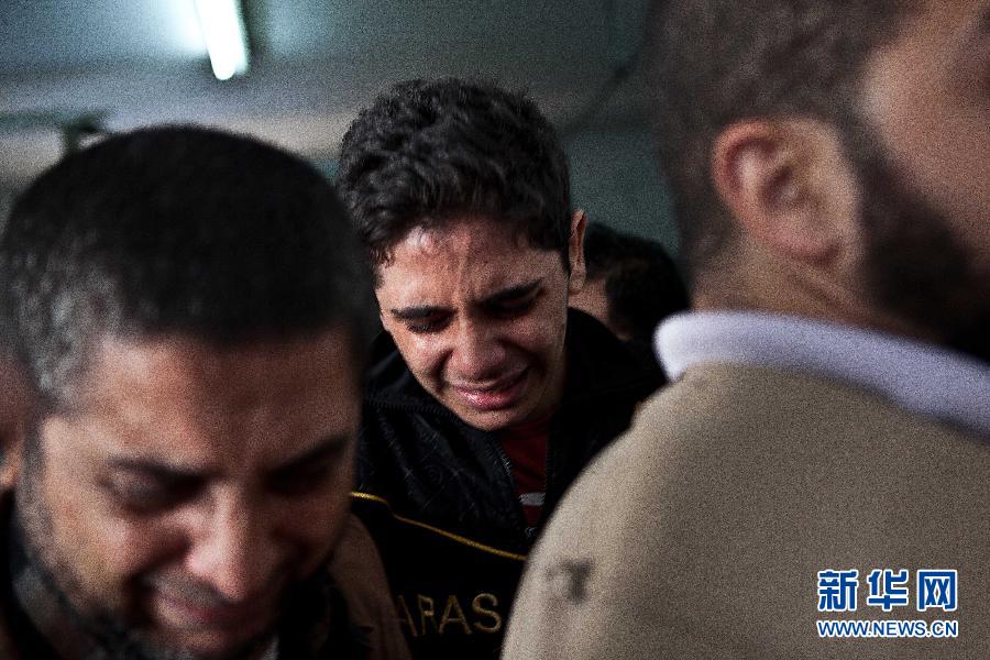 2012年11月19日，在加沙城的希法医院，达卢的儿子（中）哭着走出停放着遇难亲属尸体的太平间。达卢一家人是生活在加沙的巴勒斯坦平民，11月18日，以色列战机在空袭中将他家的房屋完全炸毁。达卢和他的一个儿子由于当时不在家中幸免于难，而包括达卢的妻子与他们的7名子女在内的11人却不幸丧生。据巴医疗部门消息，截至19日，以军空袭已造成91名巴勒斯坦人死亡，另有740多人受伤，其中包括200名儿童。加沙武装人员向以色列境内发射数百枚火箭弹，造成3名以色列人死亡。陈序 摄 图片来源：新华网 