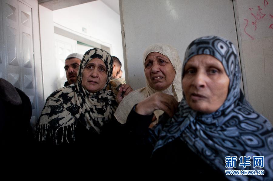 11月19日，在加沙城的希法医院，达卢的家属表情悲痛。陈序 摄 图片来源：新华网 