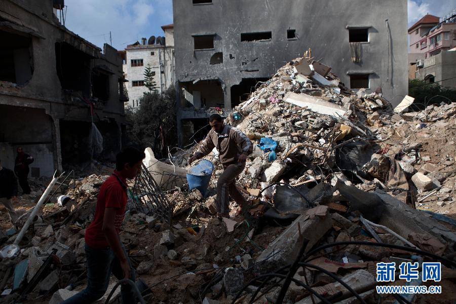11月19日，在加沙城，救援人员在达卢家被炸毁的废墟中试图寻找达卢仍然失踪的一名亲人。陈序 摄 图片来源：新华网 