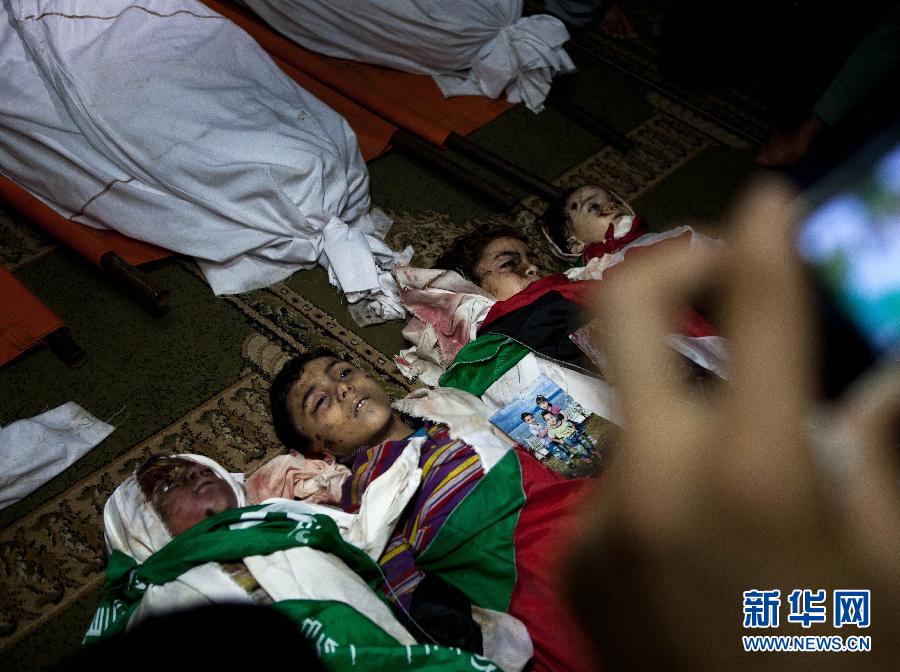11月19日，在加沙城的希法医院，达卢家的4个遇难孩子等待下葬。陈序 摄 图片来源：新华网 