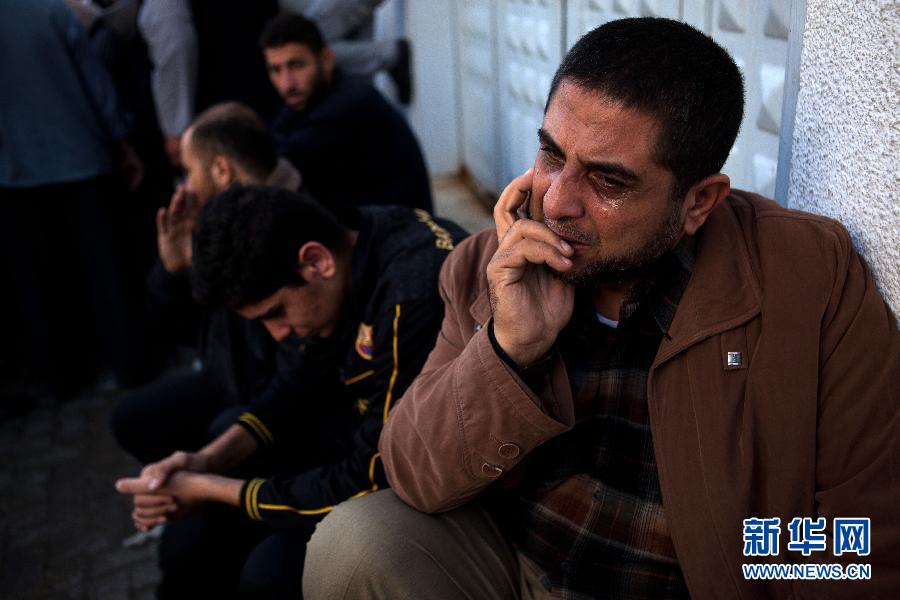 11月19日，在加沙城的希法医院，达卢（右）在停放着遇难亲属尸体的太平间外哭泣。陈序 摄 图片来源：新华网 