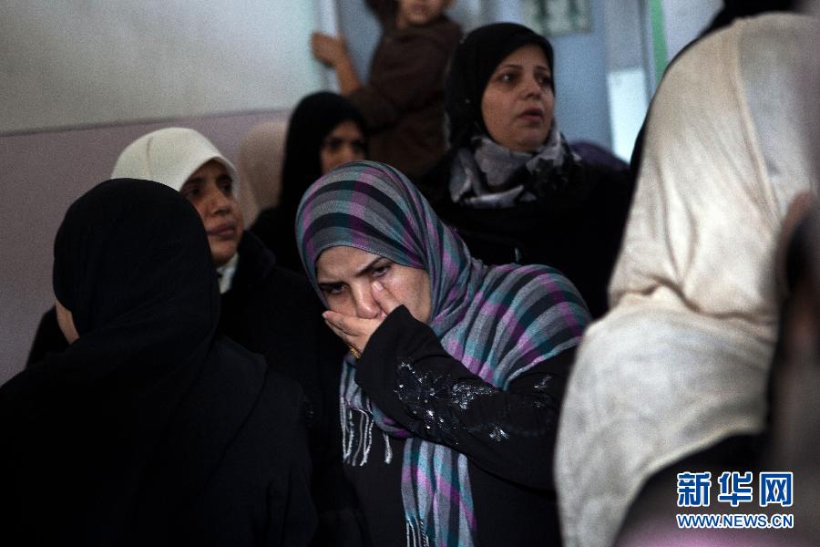 11月19日，在加沙城的希法医院，达卢的家属表情悲痛。陈序 摄 图片来源：新华网 