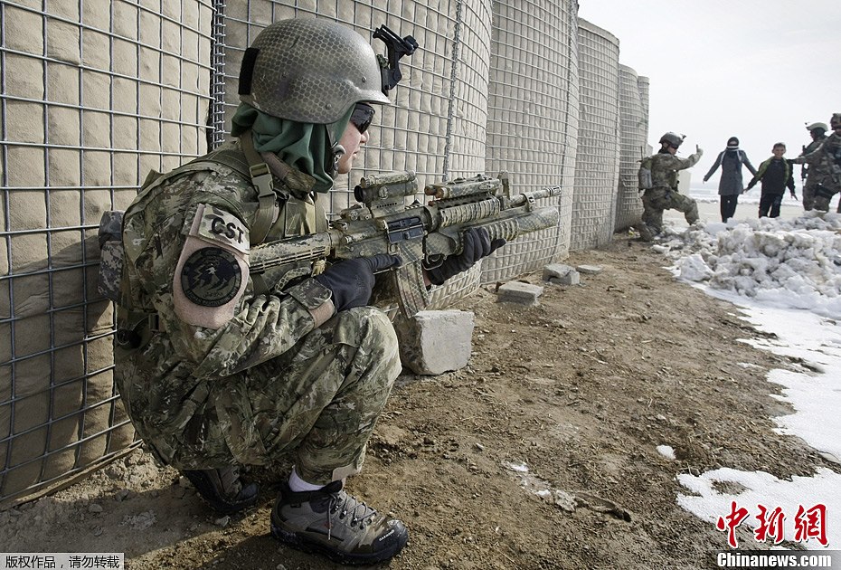 近日，阿富汗特种部队在喀布尔郊区的训练区域举行演习。阿富汗女特种兵与男性士兵同场竞技显不俗身手。图为阿富汗女特种兵在进行搜索演练。
