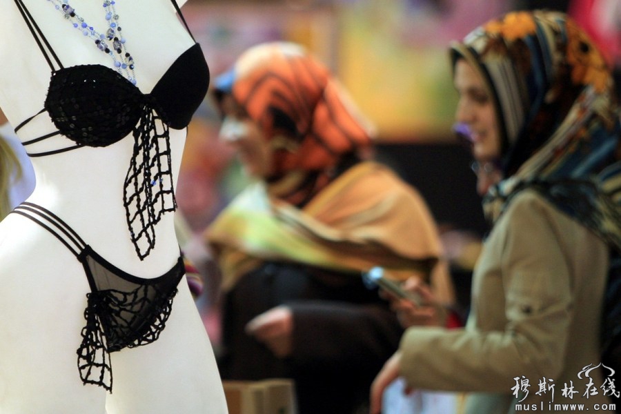 土耳其伊斯坦布尔的时装周上，几名女性穆斯林在观赏设计师的时装作品。REUTERS/Fatih Saribas