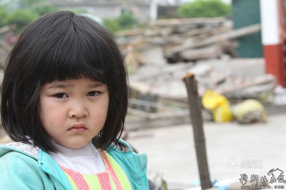 【小女孩在倒塌的房屋前】4月21日，四川省雅安市雨城区中里镇龙泉村5岁的小女孩段源源在自家倒塌的房屋前。中里镇有数栋房屋倒塌，受灾群众急缺帐篷和食物。4月20日，四川雅安芦山县发生7.0级地震。新华社记者邢广利摄