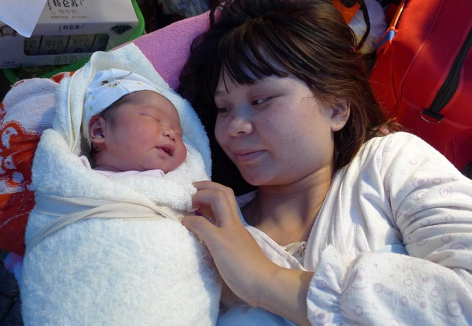 雅安市7.0级地震发生一小时后，一个新的生命降生在雅安市人民医院的车棚里。孩子的母亲正在考虑给女儿起名叫“孔震生”，以纪念2013年4月20日这个在他和女儿生命中最难忘的一天。图为月20日，“地震宝宝”躺在母亲身边。