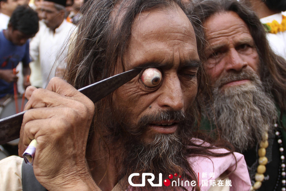 一名男子在宗教游行上用剑指着自己的眼球。图片来源：Deepak Sharma/东方IC