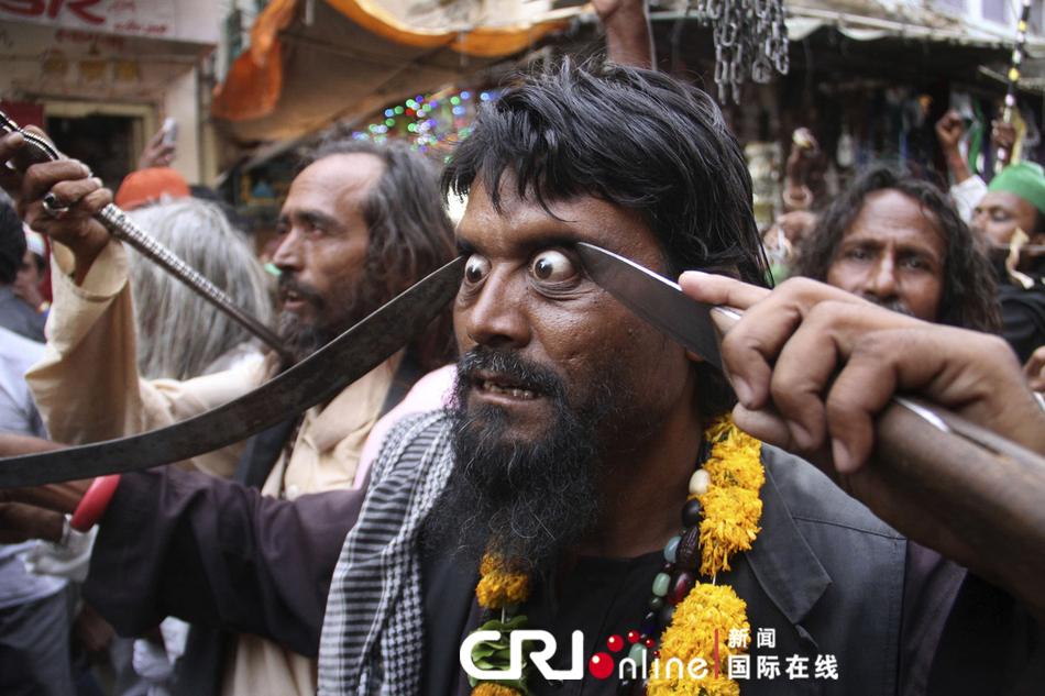 一名男子在宗教游行上用剑指着自己的眼球。图片来源：Deepak Sharma/东方IC