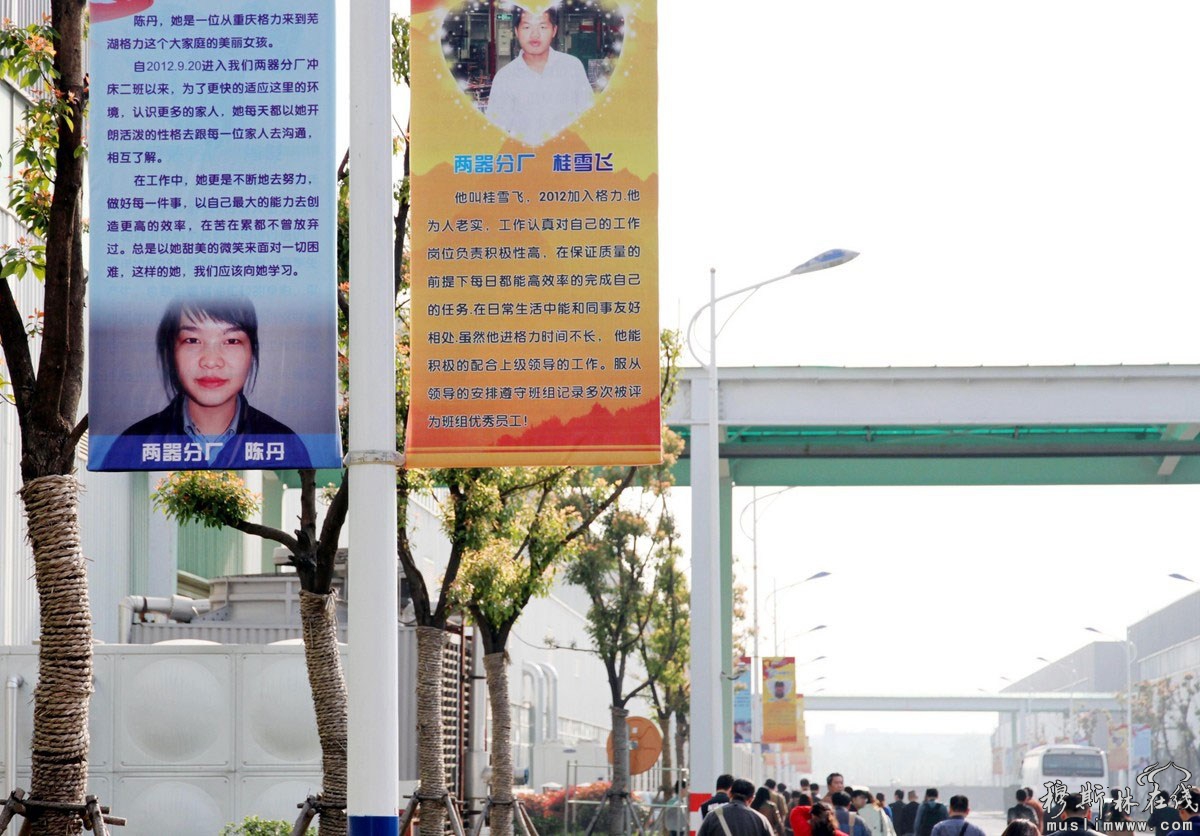 2013年4月12日，安徽芜湖，参观者从挂有“明星员工”的大幅宣传画下走过。 
