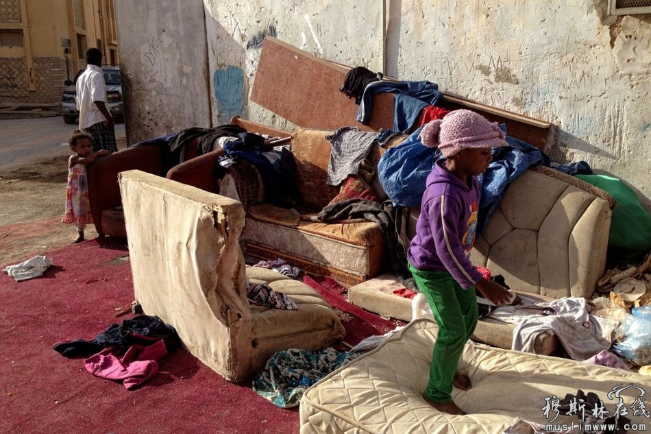 利雅得南部一处贫困区中，几个孩子在家门外的旧家具上玩耍。