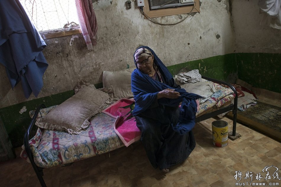贫穷的沙特妇女塞尔玛·萨利赫（Selma Saleh）坐在床上。