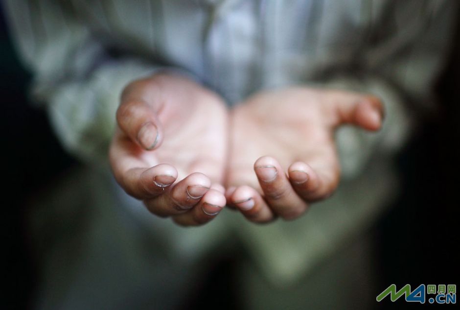 21.加德满都（尼泊尔的首都）一名男孩儿祈祷时伸出的双手.
