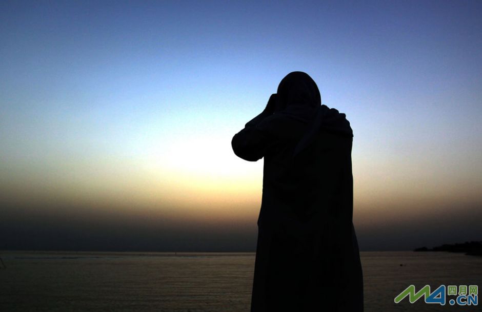 23.巴林的一位信徒在波斯湾的上空寻找新月.