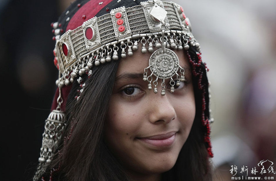 2013年7月8日，也门萨那，一名少女穿着民族传统服饰，准备参加一个庆祝斋月开始的仪式。全球的穆斯林都在迎接斋月的到来。斋月是伊斯兰教历中最神圣的一个月，斋月里，每天从黎明到黄昏信徒们都要斋戒、祈祷和内省。