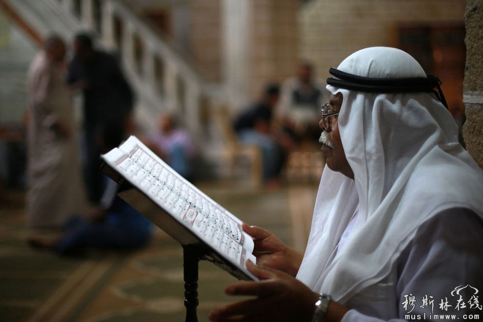 　2013年7月10日，加沙al omari清真寺，斋月开始第一天，一名男子诵读《古兰经》。斋月期间，穆斯林会到清真寺作祷告，学习《古兰经》。