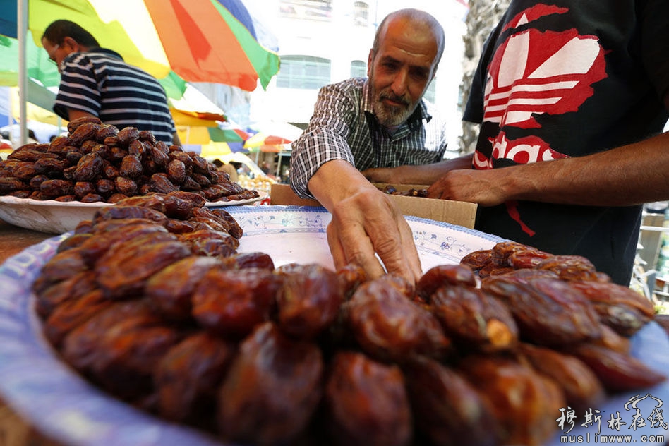 2013年7月10日，约旦河西岸城市拉马拉，斋月首日，一名商贩在摆放摊位上待售的货物。