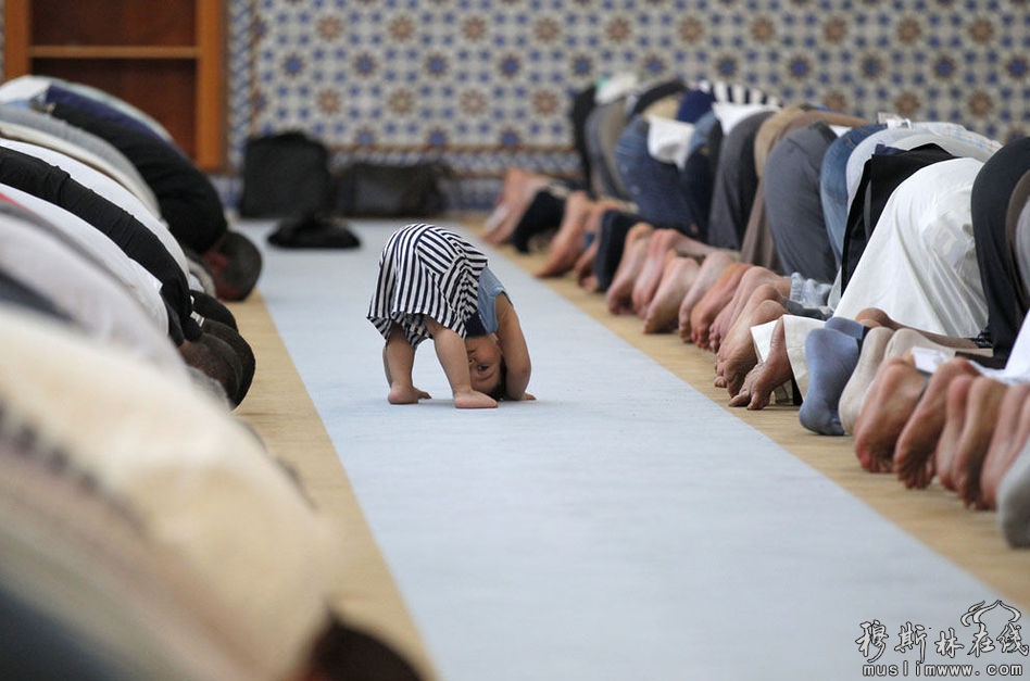 2013年7月9日，法国的斯特拉斯堡大清真寺，人们正在祈祷，一个小孩在他们身后玩耍。