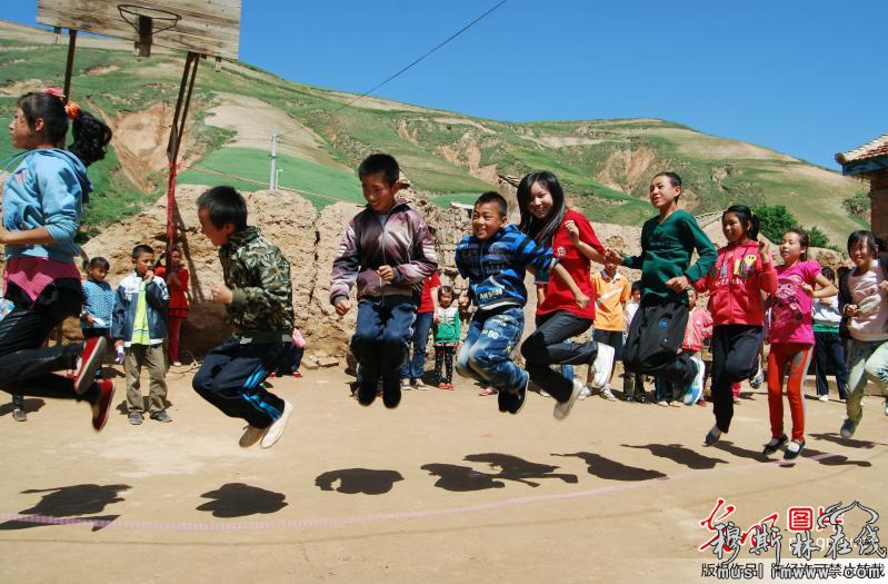  2013年7月19日，江苏大学的学生带着回族孩子们一起玩“跳大绳”游戏。