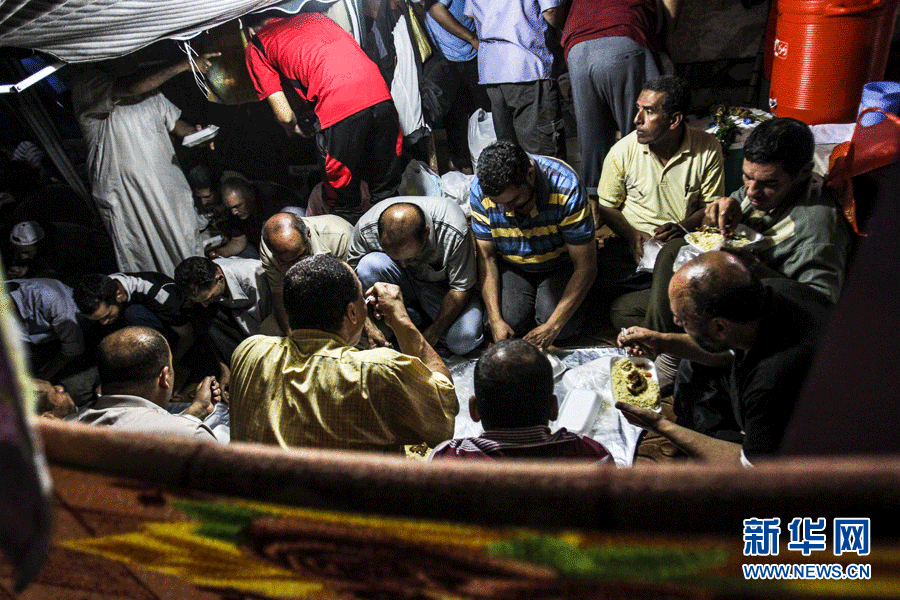 7月26日，在埃及开罗，参加抗议集会的穆尔西支持者在日落后进食。 新华社发