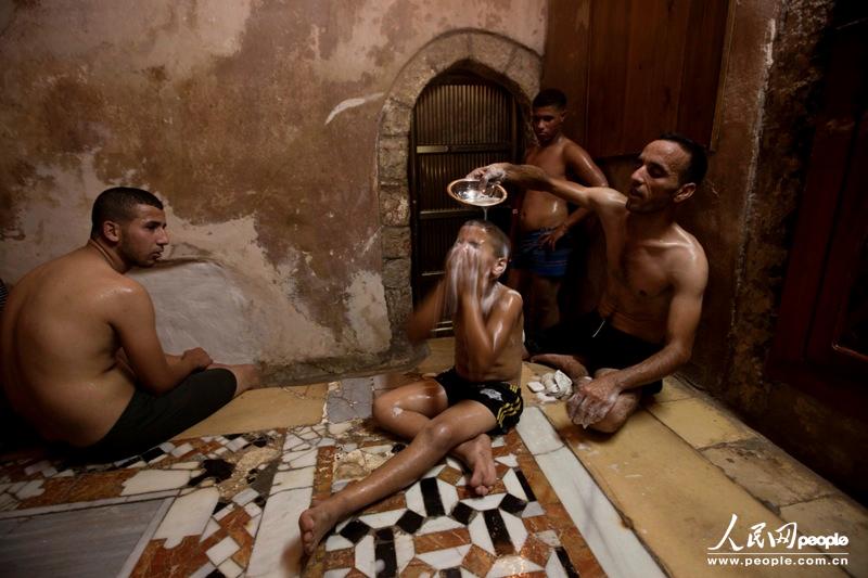 　2013年8月7日，人们在哈马·阿尔萨马拉公共浴室里为迎接开斋节沐浴放松。此时，全世界的穆斯林都在准备庆祝开斋节。开斋节有三天的假期，同时意味着斋月的结束。按照伊斯兰风俗，斋月期间，信徒在白昼时分不得喝水与进食。法新社图片/穆罕默德·哈慕斯 