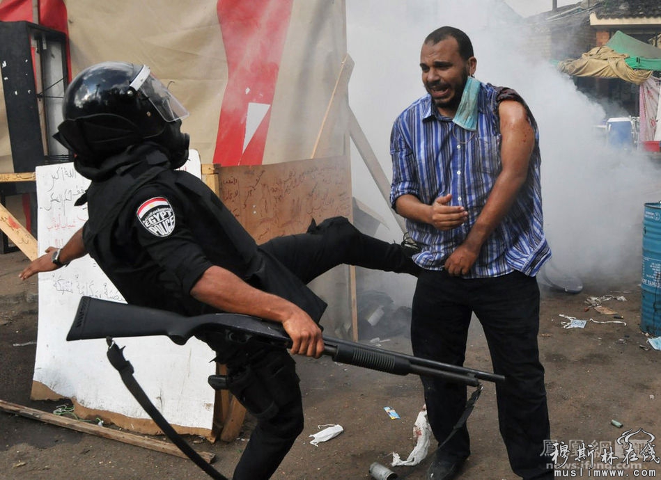 图为安全人员踢打一名受伤的示威者。