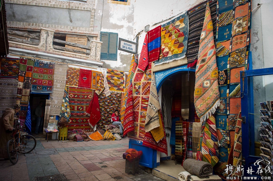这是12月18日在摩洛哥索维拉老城街巷中拍摄的色彩斑斓的手工编织地毯。新华社记者刘大伟摄