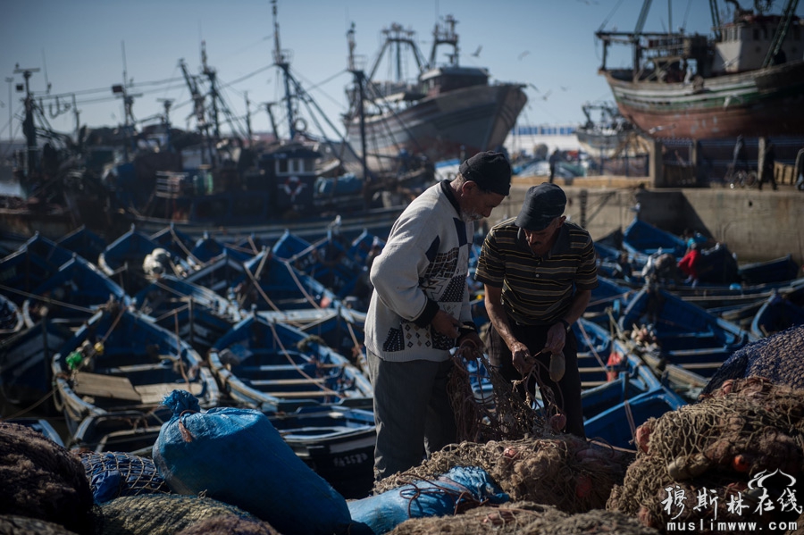 12月18日，两名当地人在摩洛哥索维拉港口整理渔网。新华社记者刘大伟摄