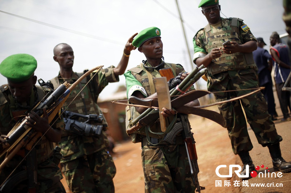 当地时间2014年1月22日,中非班吉卢旺达非盟维和人员扛着缴获的武器。图片来源:Jerome Delay/东方IC