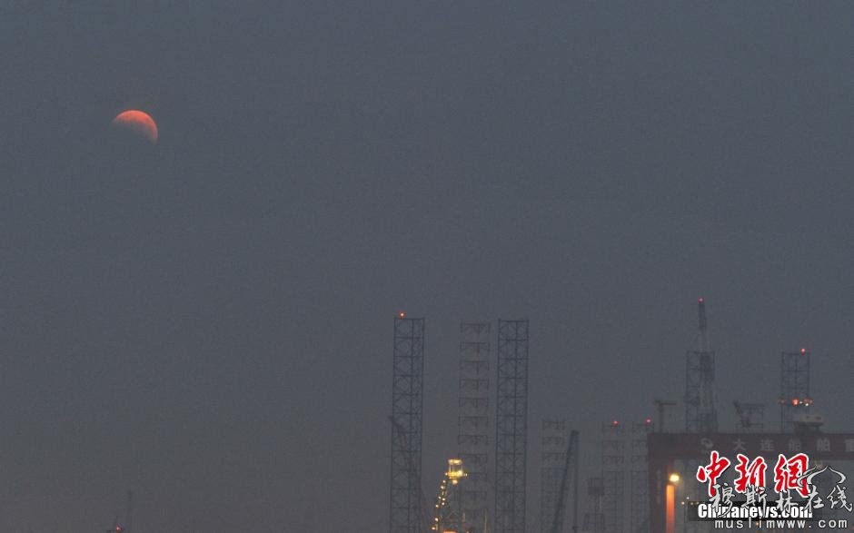 图为辽宁省大连市拍摄的“带食”而出的红月亮。