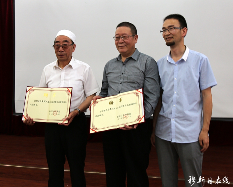 图为穆斯林在线站长马贤彪先生(右)给夏都公益名誉理事长马忠孝(中)