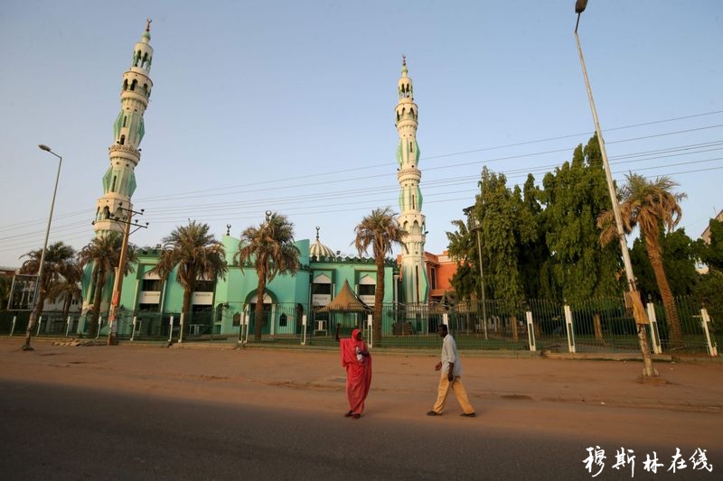 苏丹首都喀土穆，人们从大门紧锁的清真寺门前走过。